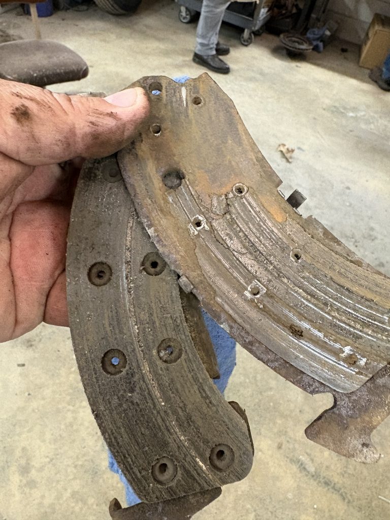 IMG_2335 A person holding a worn vehicle brake pad.